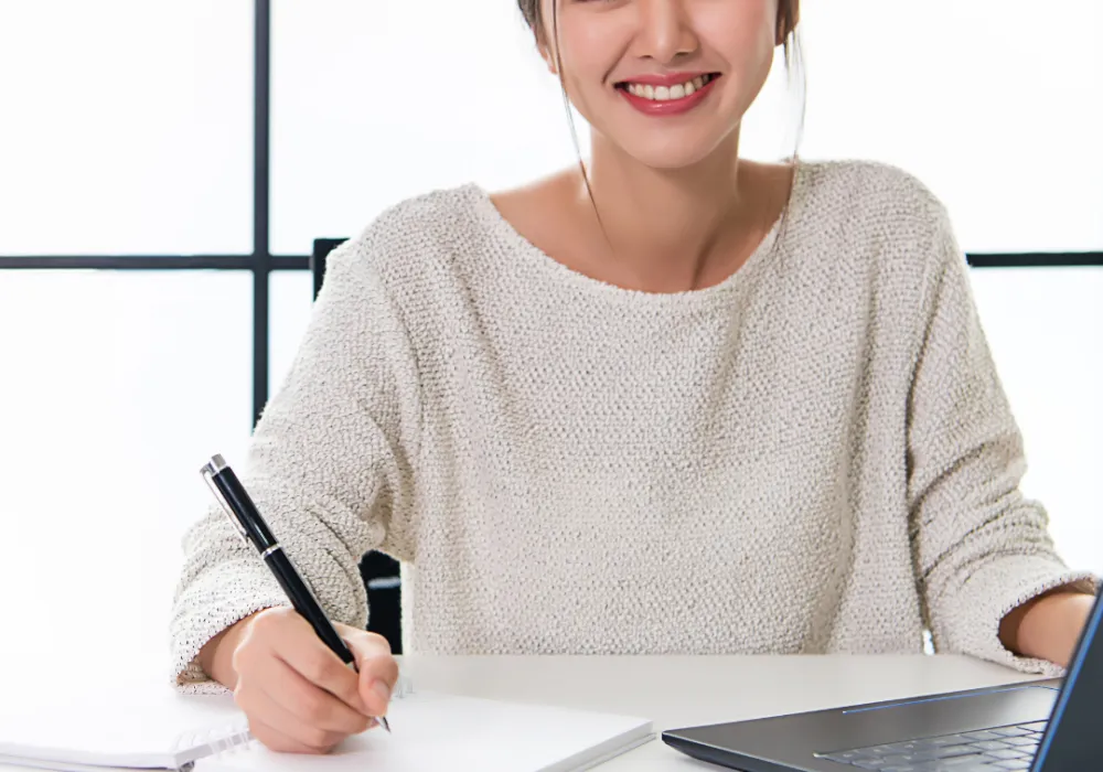 lady sitting at a desk working and smiling